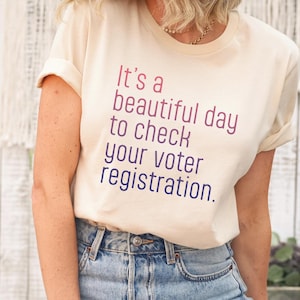 Op de afbeelding: Een wit T-shirt met de tekst "It's a beautiful day to check your voter registration."