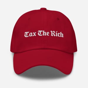May include: Red baseball cap with white embroidered text that reads "Tax The Rich" in an old English font.