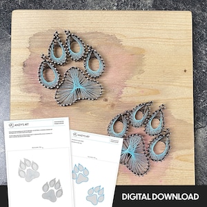 May include: Two blue and gray string art paw prints on a wooden background. The paw prints are outlined in blue string and filled in with gray string. The background is a light brown wood with a pink stain. The image also includes two printable templates for string art paw prints.