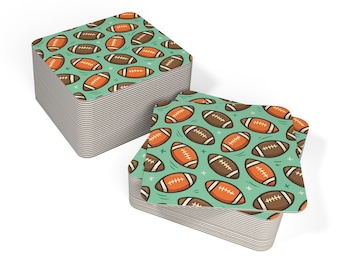 May include: Two stacks of square coasters with a repeating pattern of brown and orange American footballs on a teal background. The coasters have rounded corners and a striped edge.