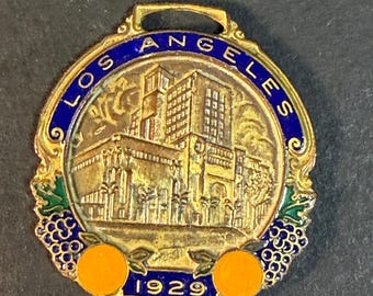 1929 Los Ángeles. Colgante de reloj de bolsillo de esmalte y metal.
