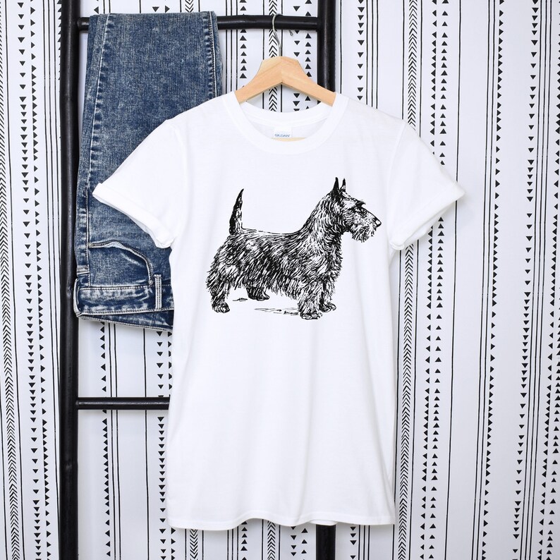 May include: White t-shirt with a black and white illustration of a Scottish Terrier.