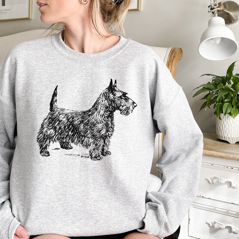 May include: A gray sweatshirt with a black and white illustration of a Scottish Terrier dog.