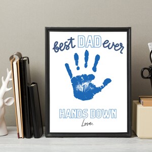 May include: A framed print with a blue handprint and the text "best DAD ever HANDS DOWN Love."