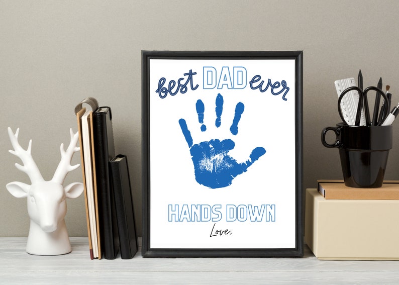 May include: A framed print with a blue handprint and the text "best DAD ever HANDS DOWN Love."