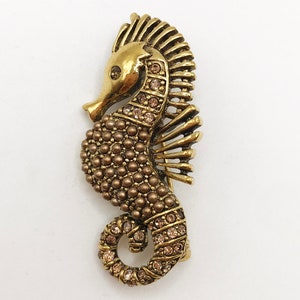 Vintage gold-tone seahorse brooch pin in an antique finish with copper-coloured rhinestones