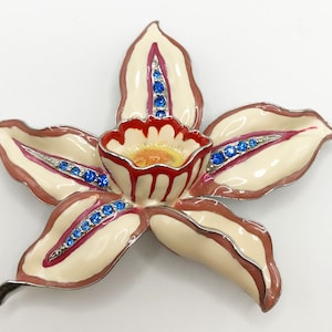 Vintage silver-tone orchid floral brooch pin with red, white, and yellow enamel and blue rhinestones
