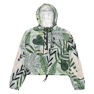 Puede incluir: Una chaqueta verde y blanca con capucha y estampado floral. La chaqueta tiene cierre de cremallera y un cordón en la parte inferior.