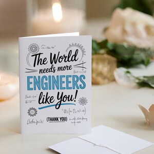 May include: A white greeting card with the text "The World needs more ENGINEERS like You!" in black and blue. The card includes mathematical symbols and the words "(THANK YOU)". An envelope is visible.