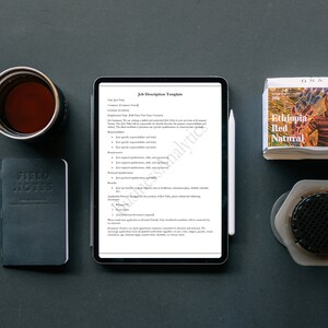 May include: A digital tablet displaying a job description template. The template includes sections for job title, company, location, employment type, and job summary. The template also includes sections for required qualifications, preferred qualifications, benefits, and application process.