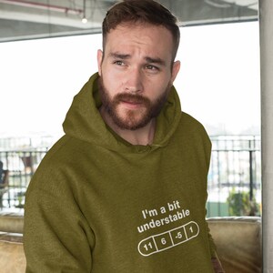 May include: A green hooded sweatshirt with the text "I'm a bit understandable" and a pill graphic with numbers 11, 6, -5, and 1.