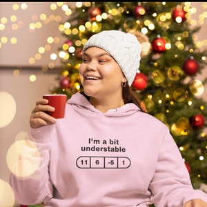 May include: Pink hoodie with a humorous graphic that reads "I'm a bit understandable" with a pill graphic showing numbers 11, 6, -5, and 1.