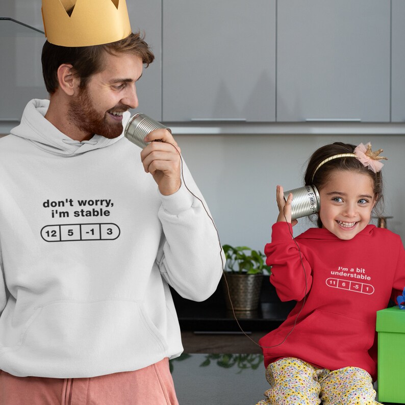 May include: A white hoodie with the text "don't worry, i'm stable" and a row of numbers "12 5 -1 3" printed on it. A red hoodie with the text "i'm a bit understandable" and a row of numbers "1 6 -5 1" printed on it.