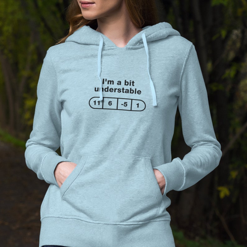 May include: A light blue hoodie with a white drawstring. The hoodie has a graphic print that says "I'm a bit understandable" with a pill shape underneath that has the numbers "11 6 -5 1" printed on it.
