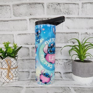 May include: A blue and pink stainless steel tumbler with a black lid. The tumbler features a repeating pattern of Stitch, a blue alien character from the Disney movie Lilo & Stitch, holding a pink heart. The text "Ohana Means Family" is printed on the tumbler.
