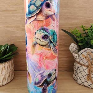 Tumbler/cup. 20oz skinny tumbler. Sea turtle design. Has blue, purple, pink, orange colors in design. Very colorful with multiple Turtles.