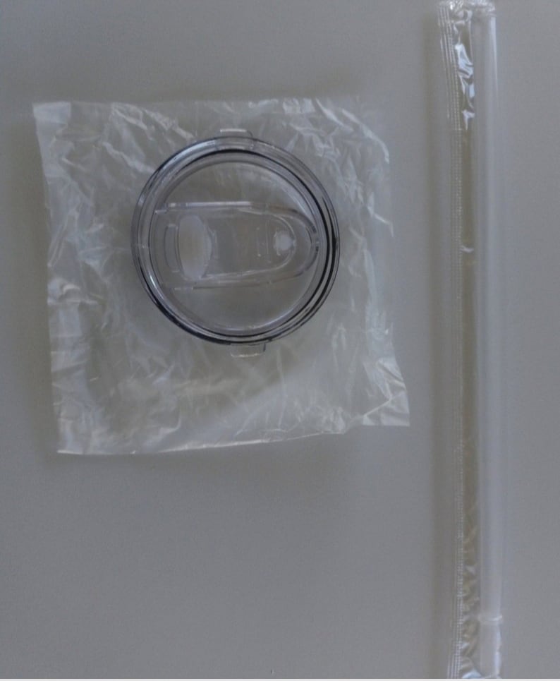 K&ouml;nnte beinhalten: Ein transparenter Plastikdeckel f&uuml;r eine Reise-Trinkflasche mit einem Schiebeverschluss. Der Deckel ist in einer transparenten Plastikt&uuml;te verpackt. Ein transparenter Plastikstrohhalm ist in einer separaten transparenten Plastikt&uuml;te verpackt.