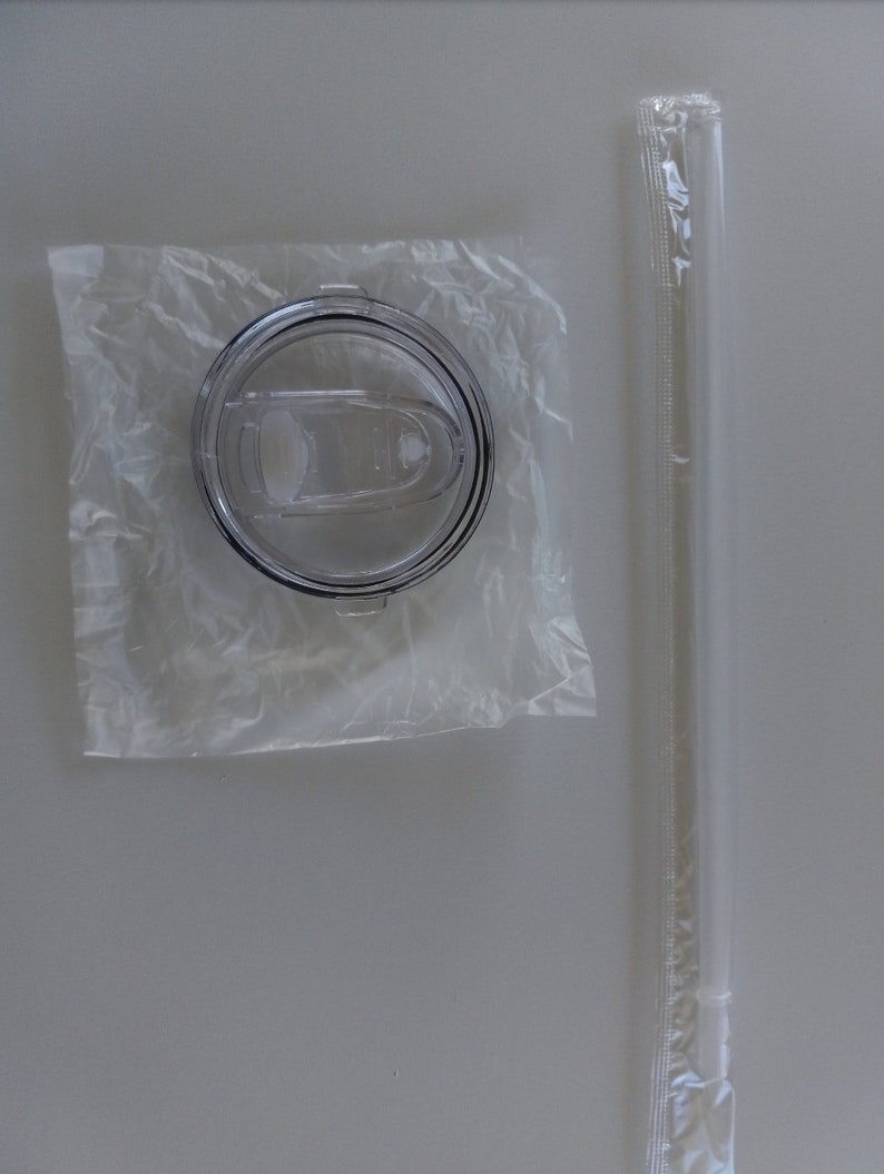Puede incluir: Una tapa de pl&aacute;stico transparente para una taza de viaje con un sello de goma negro y una pajita de pl&aacute;stico transparente en un envoltorio de pl&aacute;stico.