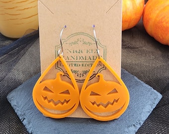 Hang/drop Halloween pompoen jack-o-lantaarn oorbellen. Oranje kleur/druppelvorm. Zilverkleurige chirurgische roestvrijstalen oorhaakjes