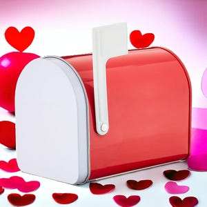 May include: A red metal mailbox with a white flag and a white door. The mailbox is surrounded by red and pink heart-shaped confetti. The background is a gradient of pink and white.