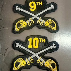 May include: Two black embroidered patches, each with crossed silver swords and a yellow skull design. One patch displays "9TH" in yellow, the other "10TH". These patches are likely military or historical in nature.