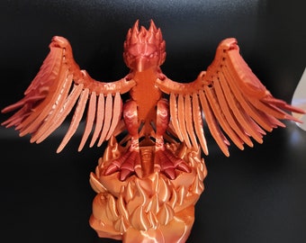 May include: A 3D printed figurine of a phoenix, with outstretched wings, standing on a base of flames. The figurine is made of a metallic orange material.