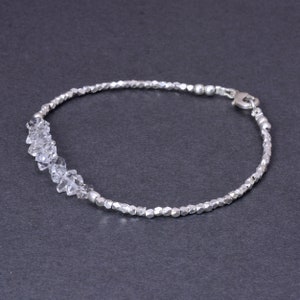 K&ouml;nnte beinhalten: Ein silbernes Armband mit einer Reihe von klaren Kristallperlen und einem silbernen Verschluss.