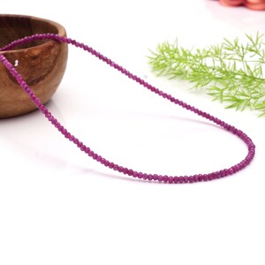 Puede incluir: Un collar delicado hecho de pequeñas cuentas redondas de rubí rosa. El collar está enhebrado en un hilo delgado y transparente y mide aproximadamente 45 cm de largo.