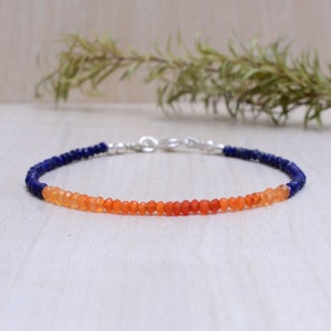 May include: A delicate bracelet with a gradient of blue lapis lazuli and orange carnelian beads. The bracelet is made with sterling silver.