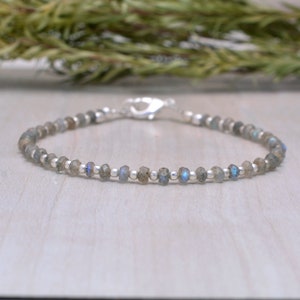 Puede incluir: Un delicado brazalete de plata con pequeñas cuentas de labradorita facetadas. El brazalete tiene un cierre de plata.
