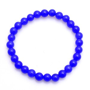 May include: A vibrant blue beaded bracelet. The bracelet is composed of numerous round, glossy beads strung together. The beads are a deep, saturated blue color, creating a striking visual contrast against the white background.