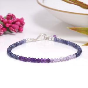 Può includere: Un braccialetto delicato con un gradiente di perline blu, viola e ametista. Il braccialetto è realizzato con chiusure in metallo argentato.
