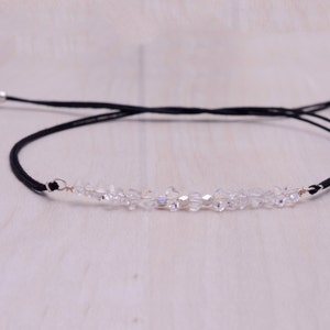 Pode incluir: Um delicado bracelete de cordão preto com uma fila de contas de cristal transparente.