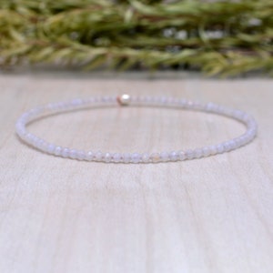 May include: A delicate white beaded bracelet with a silver clasp.