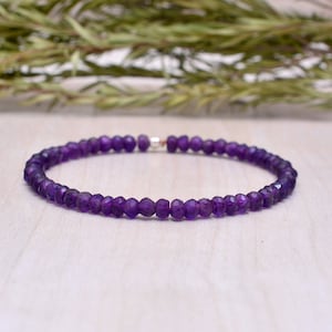 Könnte beinhalten: Ein violettes Amethyst-Perlenarmband mit einem silbernen Verschluss.