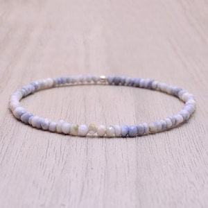 Könnte beinhalten: Eine zarte Halskette aus kleinen, facettierten, hellblauen und weißen Opalperlen. Die Halskette ist auf einer silbernen Kette aufgefädelt und etwa 45 cm lang.