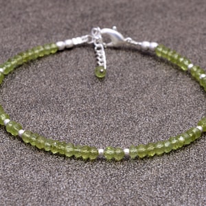 Puede incluir: Un delicado brazalete de piedras preciosas de peridoto verde con cuentas de plata y un cierre de plata.