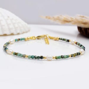 Può includere: Bracciale delicato con piccole perline turchesi quadrate, perline color oro e tre perle bianche. Il bracciale ha una chiusura color oro. Questo gioiello è adatto per l'uso quotidiano o per occasioni speciali. Design raffinato.