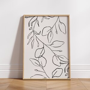 May include: A framed print with a minimalist line drawing of leaves and branches on a light pink background.
