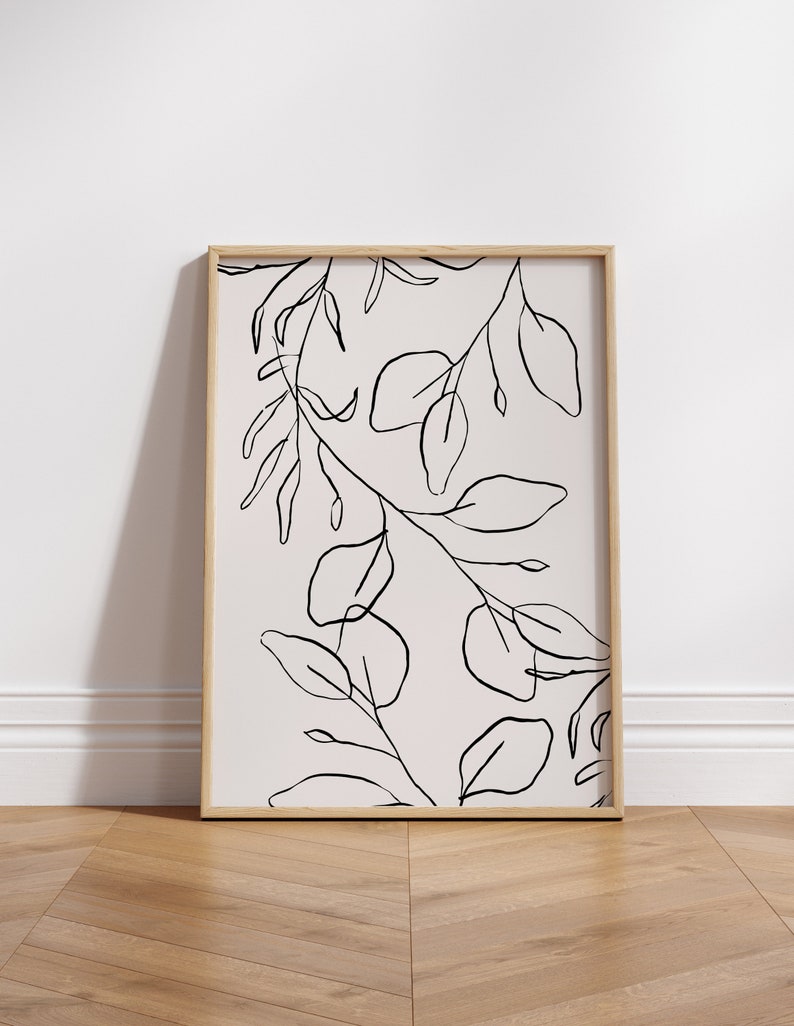 May include: A framed print with a minimalist line drawing of leaves and branches on a light pink background.