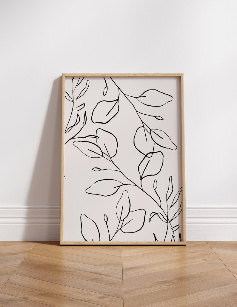 May include: A framed black and white line drawing of leaves and branches on a light pink background.