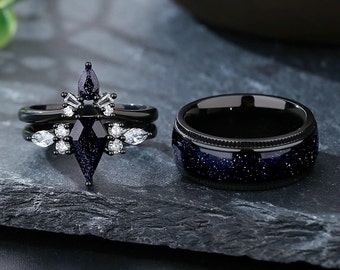Könnte beinhalten: Ein Paar schwarze Eheringe mit einem Sternenhimmel-Design. Der Damenring hat einen großen, schwarzen, sternförmigen Stein, der von kleineren weißen Steinen umgeben ist.