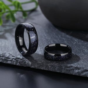 Puede incluir: Dos anillos negros con un acabado moteado azul oscuro. Los anillos est&aacute;n hechos de un material duradero y tienen un aspecto pulido.