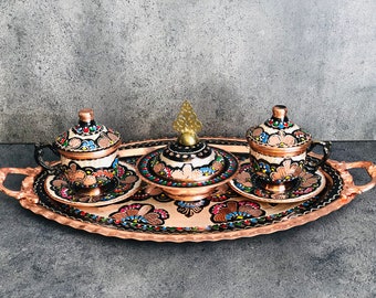 Pode incluir: Uma bandeja de servir de cobre com duas pequenas xícaras e um açucareiro com tampa. A bandeja e as xícaras são decoradas com padrões florais coloridos.