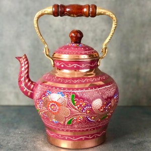May include: A traditional copper teapot with a gold handle and floral designs painted in pink, red, green, blue, and white.