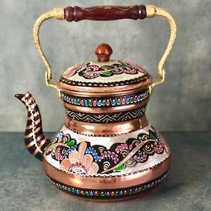 May include: A traditional Turkish copper teapot with a gold handle and a painted floral design in shades of red, blue, green, and black.