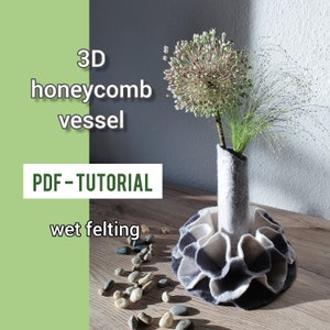 Könnte beinhalten: Eine 3D-Waben-Vase aus Nassfilzen. Die Vase ist grau und weiß und hat ein Wabenmuster. Sie hält einen Strauß getrockneter Blumen. Der Text "3D honeycomb vessel" und "PDF - TUTORIAL wet felting" ist im Bild sichtbar.