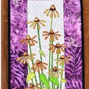 May include: A quilt block featuring a floral design with a cluster of orange and yellow flowers with green leaves on a white background. The block is framed with a purple and white patterned fabric. The text "PETAL IT PRETTY" and "Block 5 of HARE THEY ARE!" is at the top of the image. The text "10 1/2" x 29" is at the bottom of the image. The text "By: Debby Williams" is below the measurement. The text "www.quiltfever.com" is below the name. The text "Instagram: quiltfever" is below the website address.