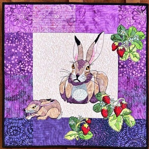 May include: A purple and white quilt block with two brown rabbits and strawberries. The quilt block is titled "Strawberry Fields" and is block 6 of "Hare They Are!" The quilt block is 20 1/2 inches by 20 1/2 inches.