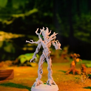 Op de afbeelding: Een wit geverfd miniatuurbeeldje van een boomwezen met een gedetailleerd, knobbelig en getextureerd oppervlak. Het beeldje staat op een ronde basis.